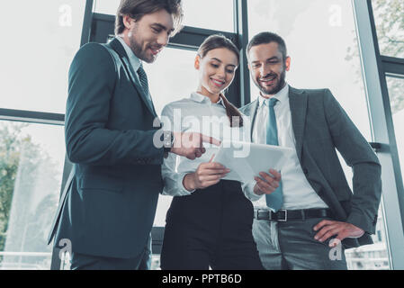 bottom view of happy business people using tablet together at modern office Stock Photo