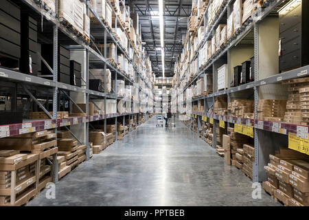 Shoppers looking for flat packed furniture stored on racks in a warehouse in Miami, USA Stock Photo