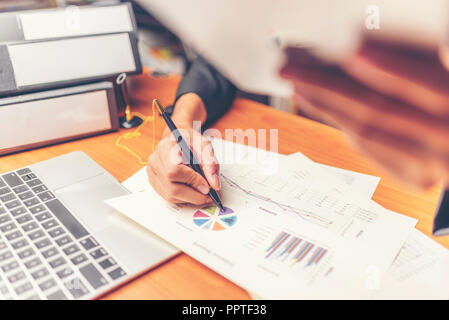 Businessmen are analyzed data from report using smartphone and laptop computer. Stock Photo