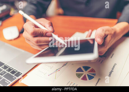 Businessmen are analyzed data from report using smartphone and laptop computer. Stock Photo