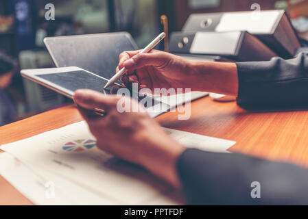 Businessmen are analyzed data from report using smartphone and laptop computer. Stock Photo