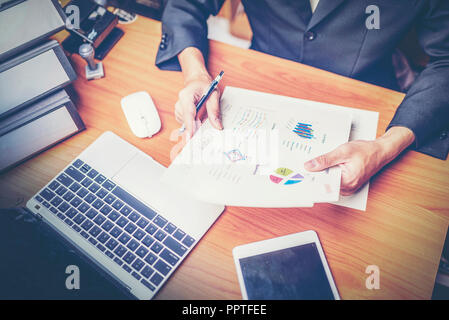 Businessmen are analyzed data from report using smartphone and laptop computer. Stock Photo