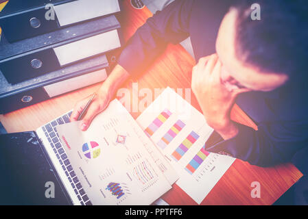 Businessmen are analyzed data from report using smartphone and laptop computer. Stock Photo
