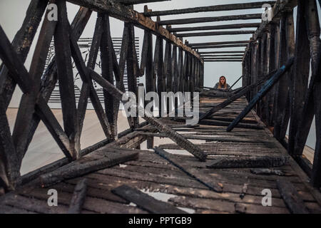 London, UK. 27th Sep 2018. Marianne Vitale, Burned Bridge, 2012 - Black Mirror the new exhibition at the Saatchi Gallery about art’s role in social satire - featuring the work of 26 contemporary artists. It runs from 28 Sept 18 to 13 Jan 19. Credit: Guy Bell/Alamy Live News Stock Photo