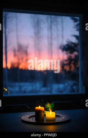 Candles on the table. Winter landscape seen through the window.Candles on the table Stock Photo