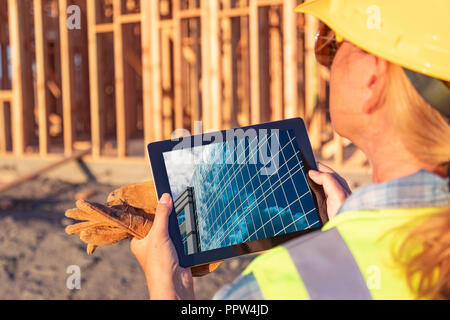 Female Construction Workers Reviewing Building on Computer Pad at Construction Site. Stock Photo