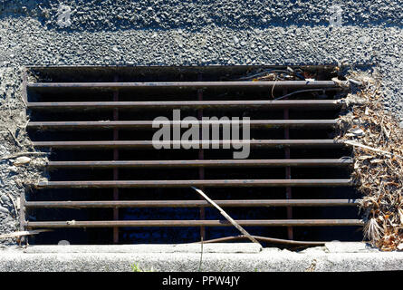 Road drainage, a grilled stormwater drain with a stick in it. Stock Photo