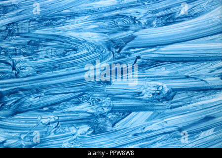 Wide wavy  smears of blue standard  cleansing gel on the window glass  macro background Stock Photo