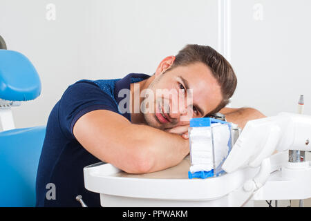 Crazy patient sitting in a dental chair Stock Photo