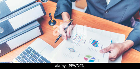 Businessmen are analyzed data from report using smartphone and laptop computer. Stock Photo