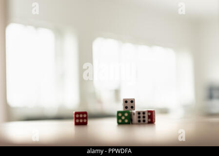 Gaming dice stacked on desk in a bright office. Stock Photo