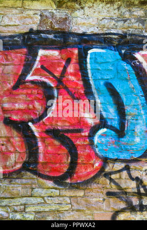 Painted graffiti on a stone brick wall. Stock Photo