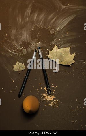 Kit of two make-up brushes with autumn seasonal theme, on a isolated colored coffee background, autumn season leaf decorations. Stock Photo