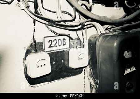 old electrical socket with wires, old electrical wiring, dangerous voltage Stock Photo