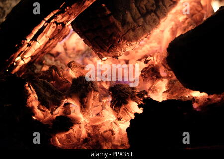 A fire's embers burning softly. This was taken at night for a higher contrast between the light and dark. Stock Photo