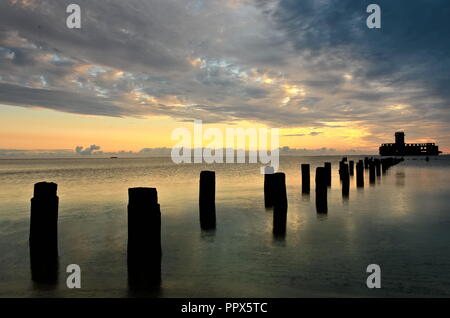 A seaside view with piles sticking from water and a construction from World War II. The photo taken by the Gdansk Gulf, Poland. Stock Photo