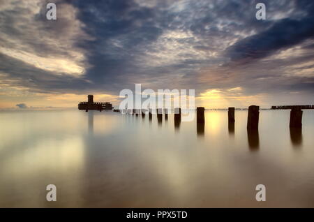 A seaside view with piles sticking from water and a construction from World War II. The photo taken by the Gdansk Gulf, Poland. Stock Photo