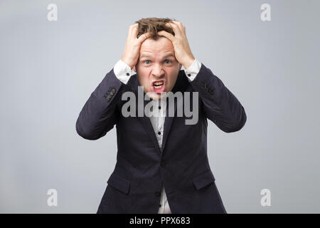 angry european businessman in dark blue suit in crazy pose. Stock Photo