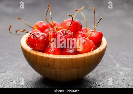 Photo of red cherry in wooden cup Stock Photo