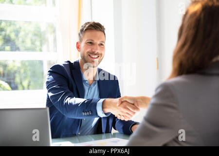 Smiling Young Businessman Shaking Hands With His Partner Stock Photo