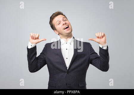 Very proud man shows his fingers on himself standong isolated on lgray background. Stock Photo