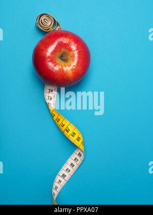 Diet or healthy eating concept with a measuring tape and organic apple Stock Photo