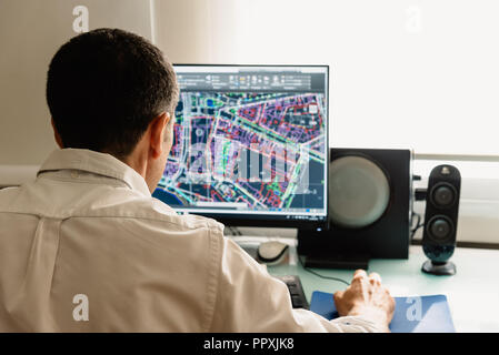 Architect drawing with cad software designing building. Rear view Stock Photo