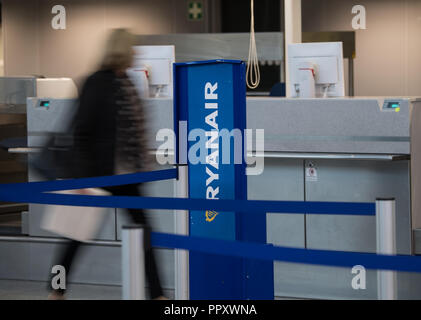 28 September 2018, Hessen, Frankfurt Main: A woman walks past the Ryanair counter at the airport. Trade unions in several European countries have called for strikes at low-cost airline Ryanair. In Germany, the pilots of the Cockpit Association (VC) and the flight attendants organized at Verdi participate. Photo: Andreas Arnold/dpa Stock Photo