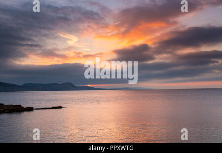 Lyme Regis, Dorset, UK. 28th September 2018.  UK Weather:  A moody sunrise and a cloudy start over the Jurassic Coast heralds an end to the glorious indian summer and the arrival of cooler, autumnal conditions.  Credit: DWR/Alamy Live News Stock Photo