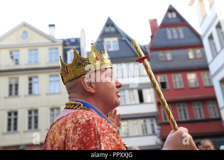 28 September 2018, Hessen, Frankfurt Main: Carl Maria Schulte stands with a metal crown in front of a row of houses on the chicken market in Frankfurt's new Old Town. The foundation stone for the controversial 200 million euro project was laid six and a half years ago. Between the cathedral and the Römer (town hall) 35 houses have been reconstructed in the past years on an area of only seven hectares, partly true to the original. The city celebrates the opening with a three-day festival. Photo: Arne Dedert/dpa Stock Photo