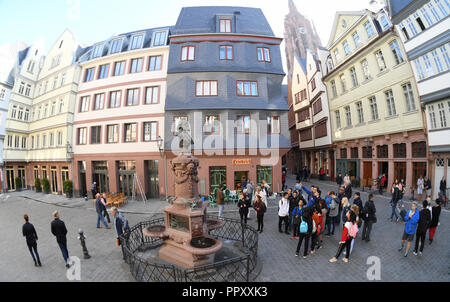 28 September 2018, Hessen, Frankfurt Main: Tourists are standing on the chicken market in Frankfurt's new Old Town at the restored Friedrich Stoltze fountain. The foundation stone for the controversial 200 million euro project was laid six and a half years ago. Between the cathedral and the Römer (town hall) 35 houses have been reconstructed in the past years on an area of only seven hectares, partly true to the original. The city celebrates the opening with a three-day festival. Photo: Arne Dedert/dpa Stock Photo