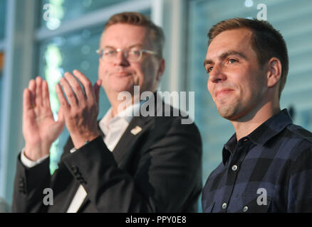 28 September 2018, Hessen, Frankfurt Main: Reinhard Grindel (l), President of the German Football Association (DFB), applauds Philipp Lahm, Ambassador of the DFB for the European Championship application, at a reception for employees and the delegation at the DFB headquarters. The day before, the Uefa had awarded the 2024 European Soccer Championship to Germany. Photo: Arne Dedert/dpa Stock Photo