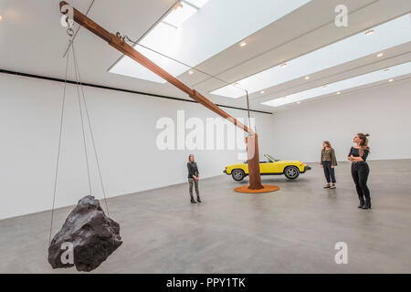 London, UK. 28th Sep 2018. Porsche with Meteorite (2013) -  Measured, an exhibition of two large-scale works by Chris Burden at the Gagosian gallery. A Porsche 914 sports car is suspended in equilibrium with a meteorite. The Porsche, at 993.4 kilograms (2,190 lbs.), weighs down the short end of the beam, and the meteorite, at 176.9 kilograms (390 lbs.), counterbalances it on the long end. Credit: Guy Bell/Alamy Live News Stock Photo