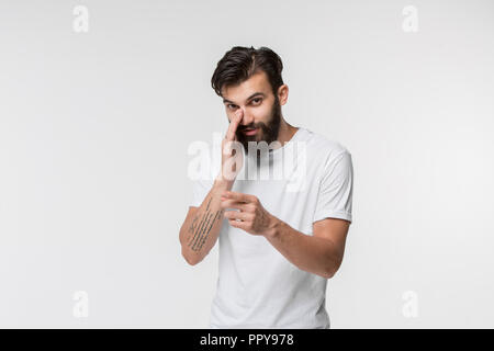 Secret, gossip concept. Young man whispering a secret behind his hand. Businessman isolated on white studio background. Young emotional man. Human emotions, facial expression concept. Stock Photo