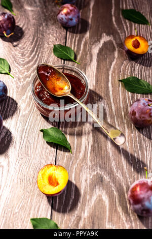 Plums and jam of plum on wood background . Stock Photo