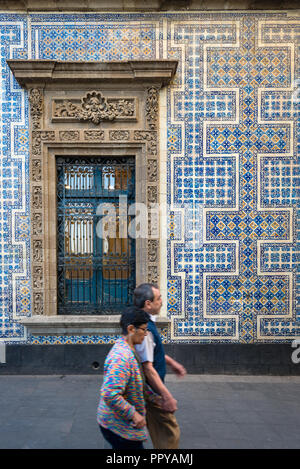 Couple walking past exterior wall of Casa de los Azulejos in Mexico City Stock Photo