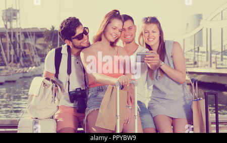 Group of friends travellers smiling and making selfie with mobile phone Stock Photo