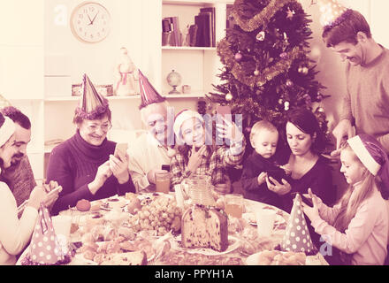 Large happy russian  family making numerous photos during Christmas dinner Stock Photo