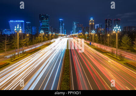 Chengdu, Sichuan province, China - Sept 27, 2018: Traffic light trails on Tianfu avenue at night with illuminated skyscrapers in the background Stock Photo