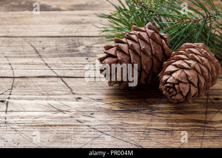 Pine cones and spruce branches on wooden background. Selective focus.Copy space. Stock Photo