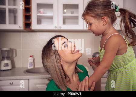 Happy family - Smiling mother playing with her cute kid girl at home Stock Photo