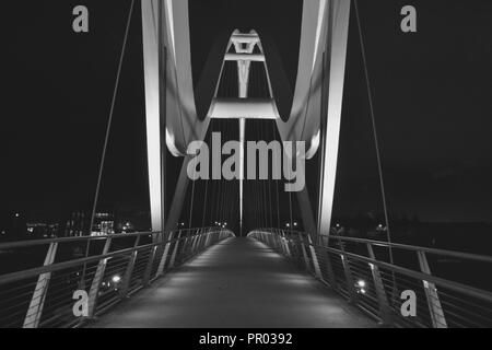 Striking, black and white night time image of the beautiful Infinity Bridge whilst illuminated, in Stockton-on-Tees, Teesside, UK. Stock Photo