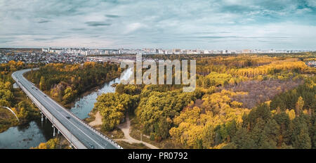 Drone view of road across the Miass river; beautiful city forest with autumn golden colored trees, rest and recreation area in center of Chelyabinsk,  Stock Photo