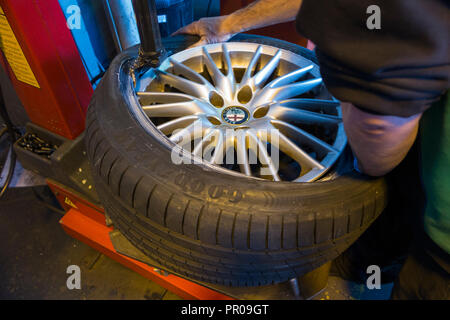 A Mechanic Replacing Car Wheels Using An Electric Wrench Tyre Mounting ...