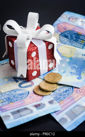 Red toy gift and euro on black Stock Photo