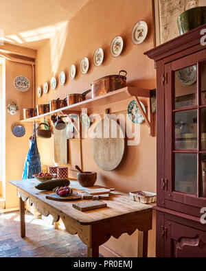 Rustic farmhouse kitchen with large chopping board and copper pans Stock Photo