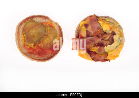 Open bacon cheeseburger showing strips of bacon, yellow american cheese, pickles, ketchup and mustard on bun Stock Photo