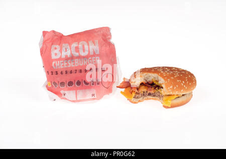 2 Burger King bacon cheeseburgers, one with a bite taken out and one in wrapper Stock Photo