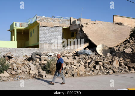 Destroyed (right) and rebuilt residential building in Bashiqua, northern Iraq, Kurdistan Stock Photo