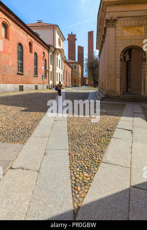 One person walks in a street with medieval towers in the background, Pavia, Pavia province, Lombardy, Italy, Europe Stock Photo